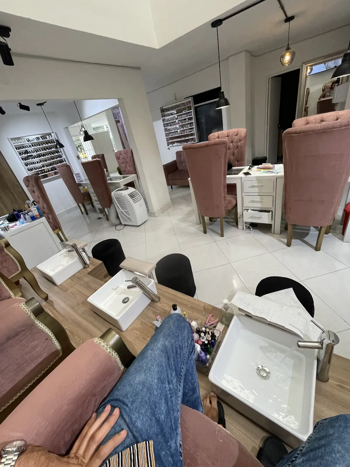 Salón de Fraga Spa con sillas de terciopelo rosa y estaciones de manicura