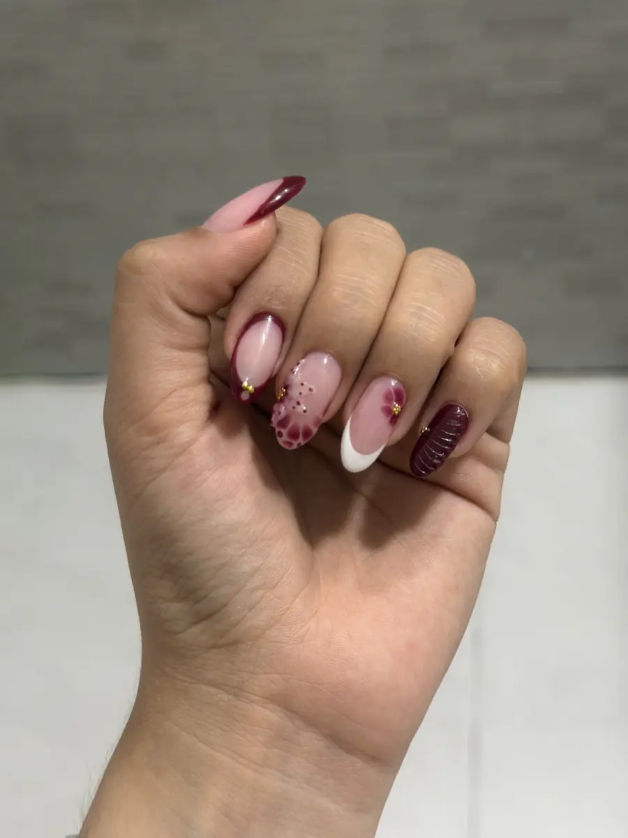 Uñas largas con diseño en tonos rosa y vino